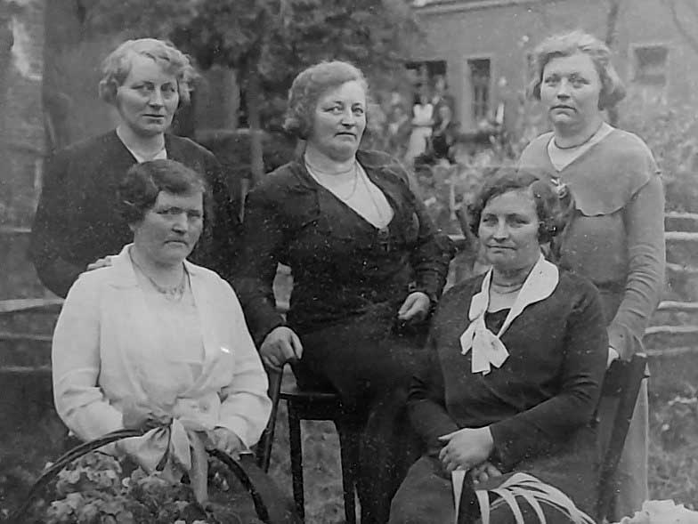 Na 1933, bij tante Stien in de tuin, Ollandseweg 1, Sint-Oedenrode. V.l.n.r.: Stien (staat), Lies, Jans, Fien (oma) en Clara. Oma is het oudst, plm. 50 jaar, is dan al een jaar of zeven weduwe, Clara is met plm. 40 jaar de jongste. Tante Stien is dan pas (laat) getrouwd (zie de bloemenmanden).