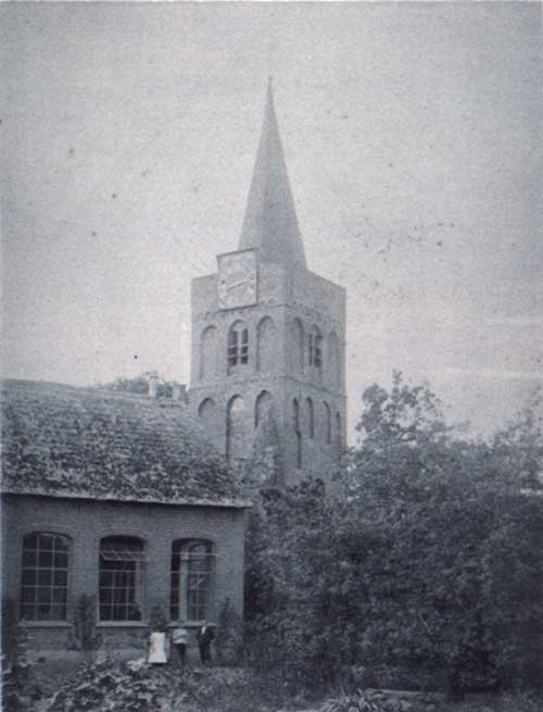 Andel, Een oude opname van de Romboutstoren. De toren heeft dan nog maar twee wijzerplaten. Die zijn dan ook nog van hout. Voor de toren staat de lagere school, ca. 1910 (Salha, and00630)