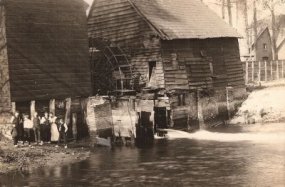 Foto uit 1910, genomen door de Boxtelse kunstschilder Pierre Janssen. Twee jaar later, in 1912, zouden deze molens verdwijnen. De dubbele watermolen op het Smalwater te Boxtel. Rechts, achter de molen zijn de sheddaken van Van Oerle's damastweverij zichtb