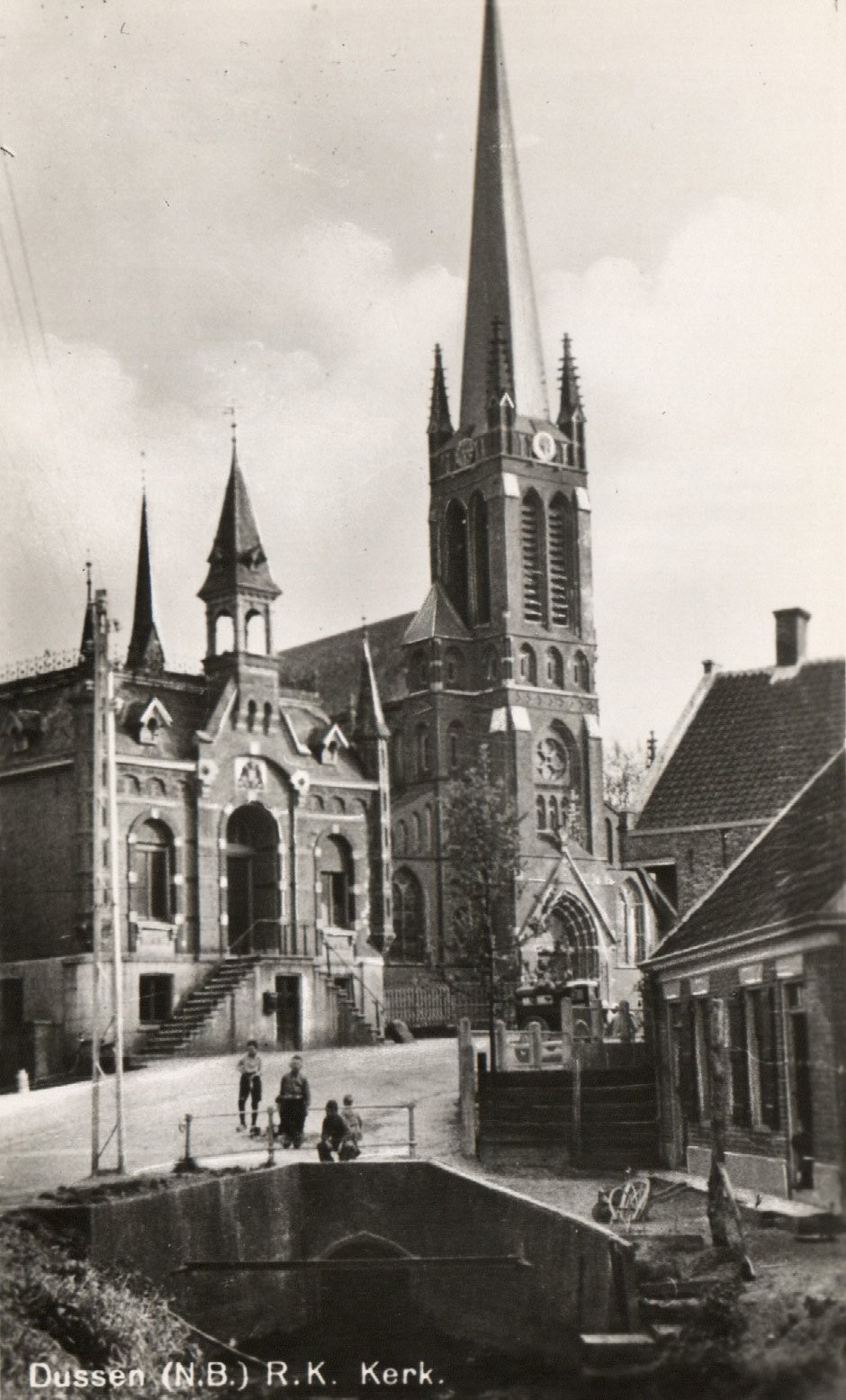 Dussen,  Ansichtkaart van de vooroorlogse Sluis te Dussen met links het Raadhuis, midden de rooms-katholieke kerk. Op de voorgrond de heul 