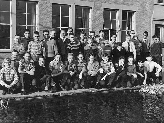 2. Groepsfoto van alle juvenisten, bij de grote visvijver, circa 1960. Op de achtergrond de refter.