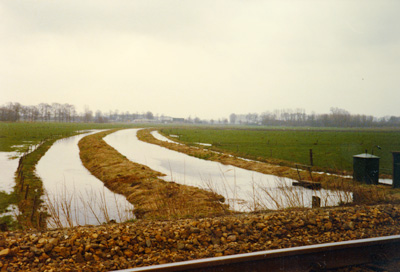 Hoogwater in en rond de rivier de Broekleij, gezien vanaf de spoorlijn richting Rijksweg N65, 1981 (BHIC, Beeldcollectie Waterschap De Zandleij)